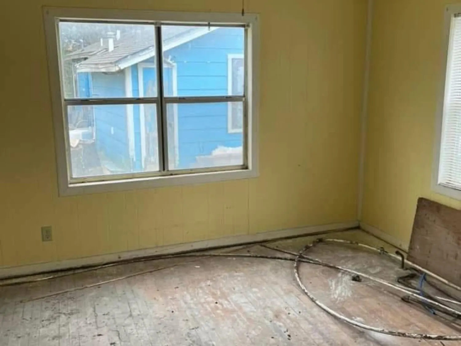Duplex room with torn-out flooring and open floor areas